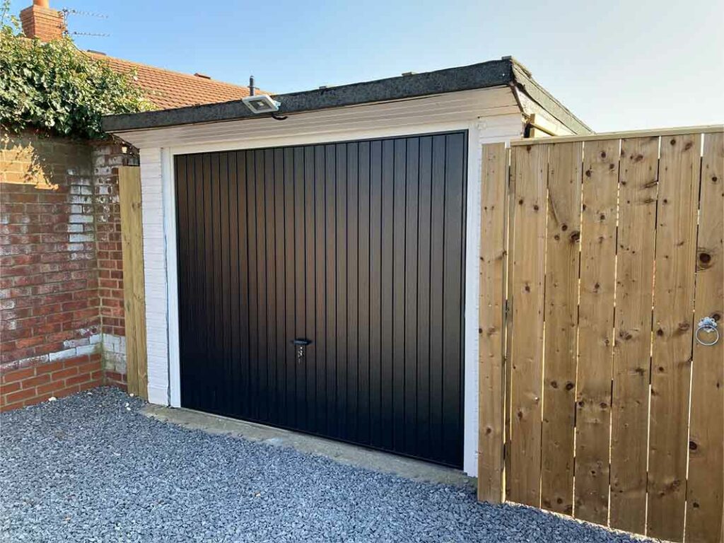 Black vertical rib garage door with a contemporary design on a white garage